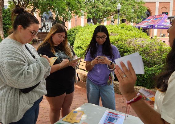 Several women stand in front of a voting table